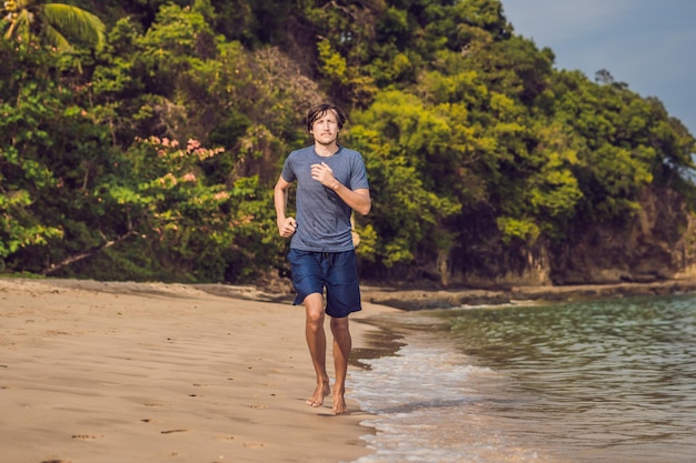 Homem jovem malhando na praia, homem esportivo fazendo exercícios
