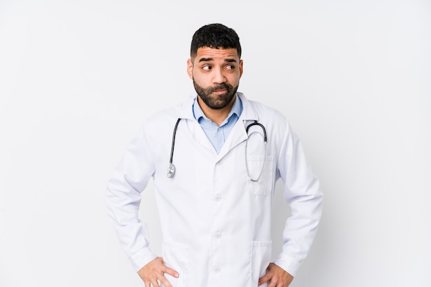 Homem jovem médico árabe isolado confuso, sente-se em dúvida e inseguro.