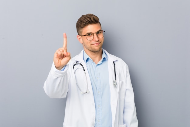 Homem jovem médico mostrando o número um.