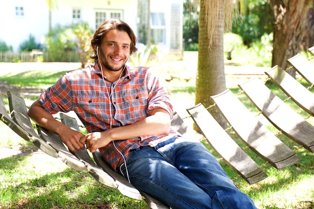 Homem jovem, mentindo, em, rede, com, fones ouvido