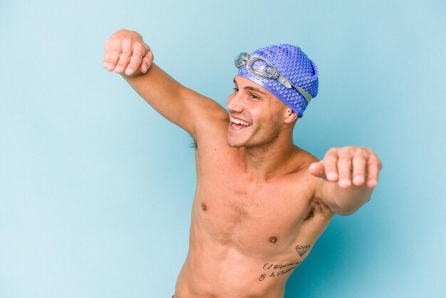 Homem jovem nadador caucasiano isolado em fundo azul