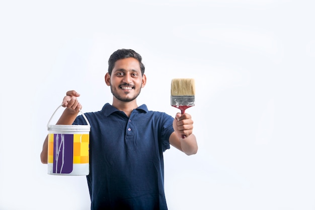 Homem jovem pintor indiano sobre fundo branco.