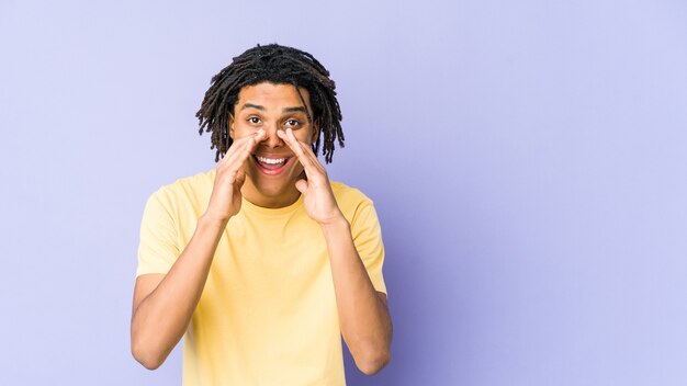 Homem jovem rasta americano africano dizendo uma fofoca, apontando para o lado relatando algo.