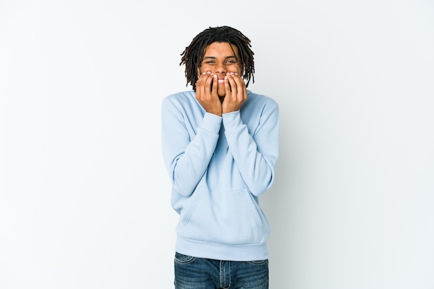 Foto homem jovem rasta americano africano rindo de algo, cobrindo a boca com as mãos.