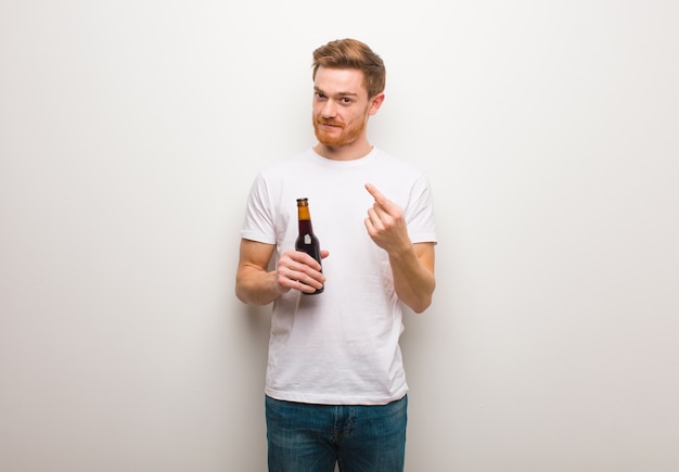 Homem jovem ruiva. Segurando uma cerveja.