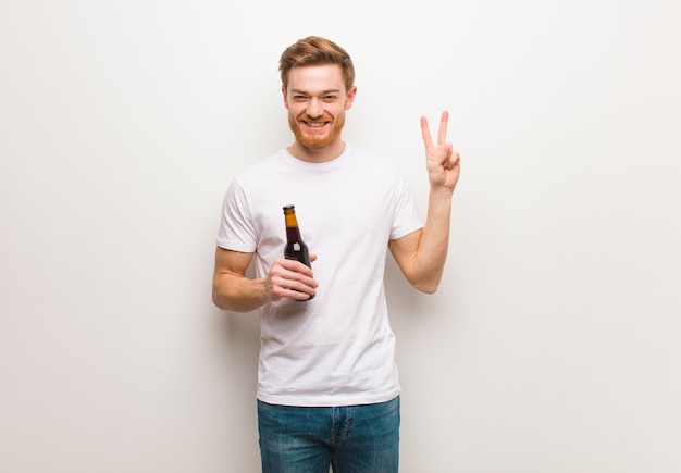 Homem jovem ruiva. segurando uma cerveja.