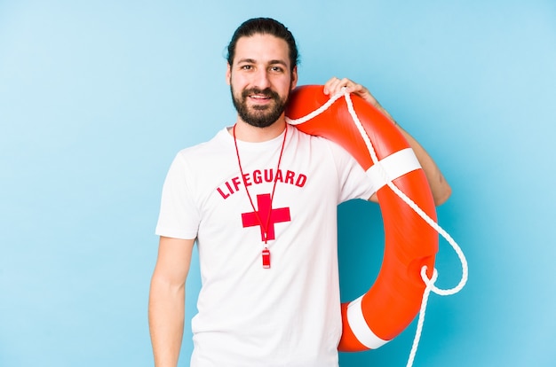 Homem jovem salva-vidas segurando um flutuador de resgate isolado feliz, sorridente e alegre.