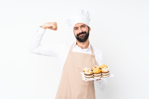 Homem jovem, segurando, bolo muffin, fazendo, gesto forte