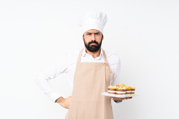 Homem jovem, segurando, bolo muffin, sobre, isolado, branca, irritado