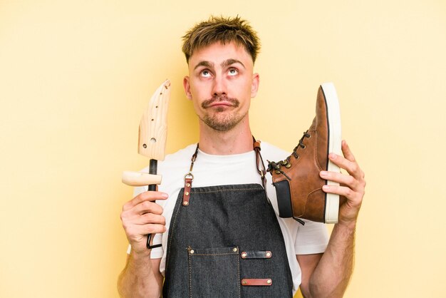 Homem jovem shoemarket isolado em fundo amarelo