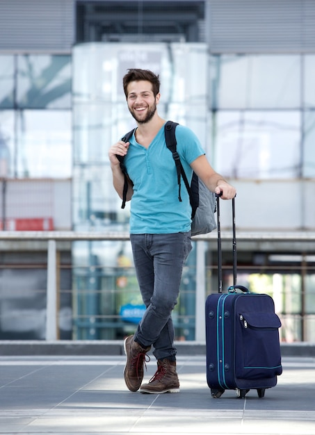 Homem jovem, sorrindo, com, sacolas, em, aeroporto