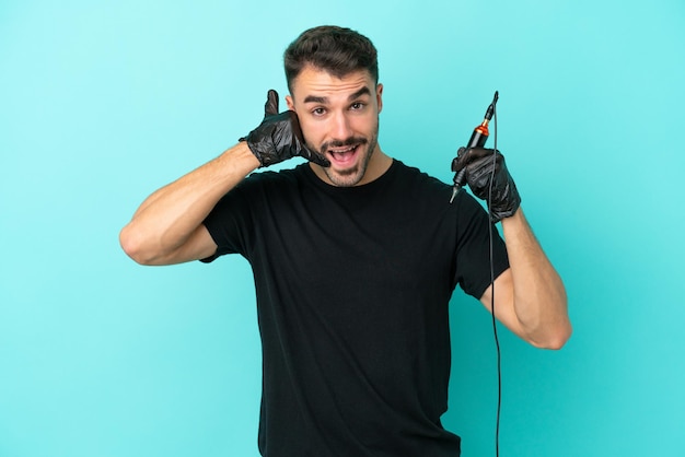 Homem jovem tatuador isolado em fundo azul fazendo gesto de telefone Ligue-me de volta sinal