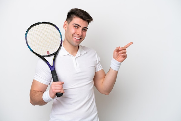Homem jovem tenista isolado no fundo branco, apontando o dedo para o lado