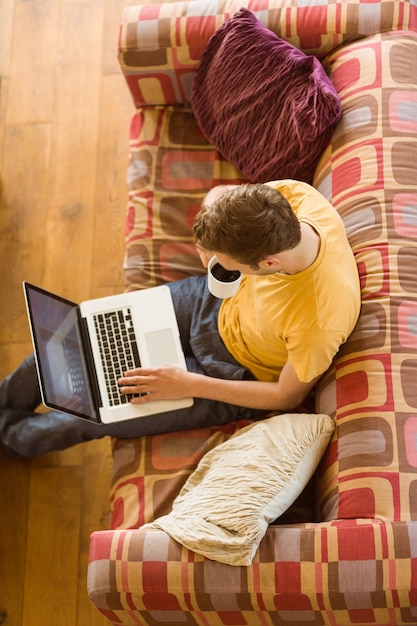 Homem jovem, usando computador portátil, ligado, seu, sofá