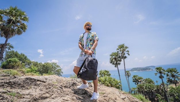 Homem jovem viajante nas férias de verão com belas montanhas e paisagens marítimas ao fundo