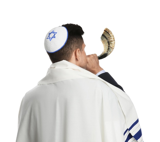 Foto homem judeu com kipá e talit tocando shofar na celebração de rosh hashaná de fundo branco