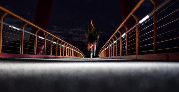 Foto homem junto à ponte iluminada à noite