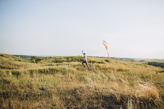 Homem lançando pipa de ar colorido no campo