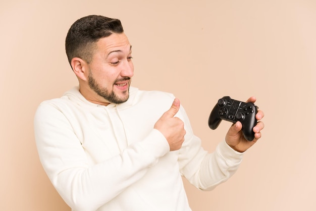 Homem latino adulto brincando com um controlador de jogo isolado