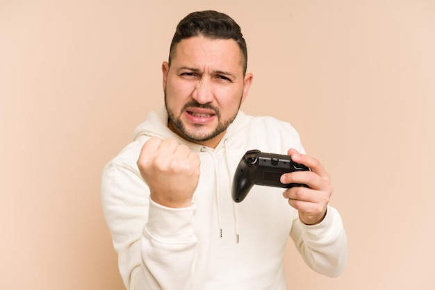 Homem latino adulto brincando com um controlador de jogo isolado