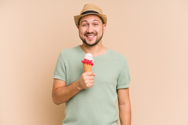 Homem latino adulto comendo um sorvete isolado em fundo bege