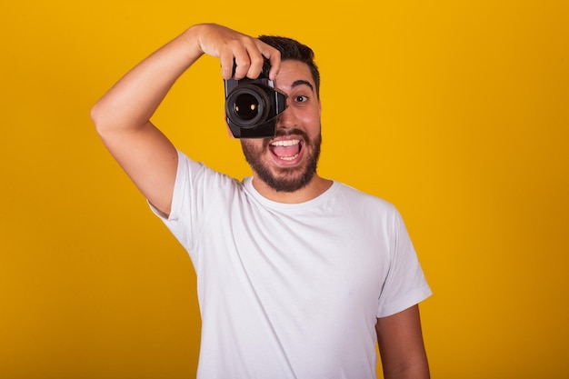 Homem latino-americano brasileiro feliz segurando o conceito de câmera digital de fotografia fotógrafo profissão passatempo passatempo