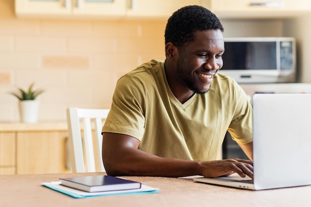 Homem latino-americano freelancer usando laptop estudando online trabalhando em casa