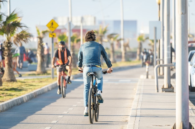 homem latino andando de bicicleta em uma ciclovia ao pôr do sol em La Serena