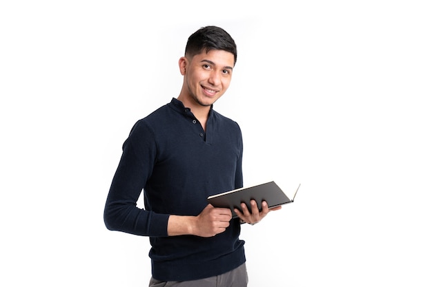 Homem latino com livro nas mãos sorrindo olhando