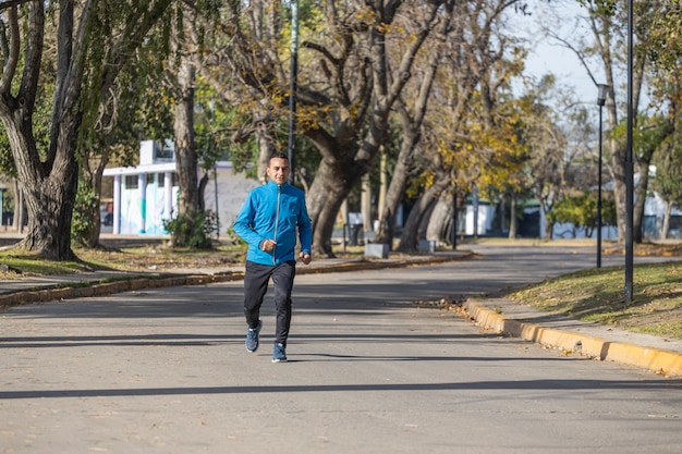 Homem latino corre por um parque público