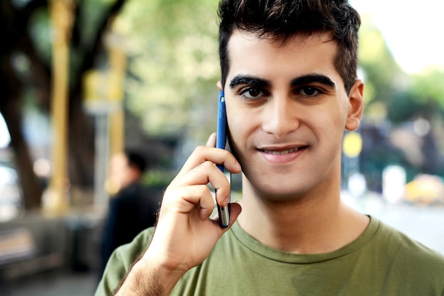 Homem latino, falando telefone