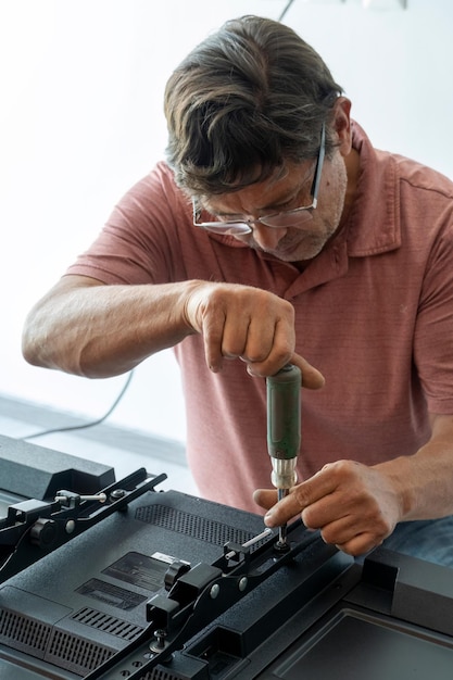 Homem latino mexicano reparando uma tela de tv verificando falhas