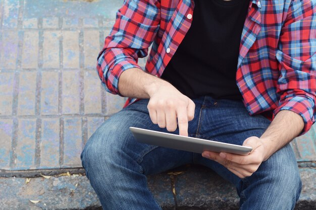 Homem latino usando um tablet.