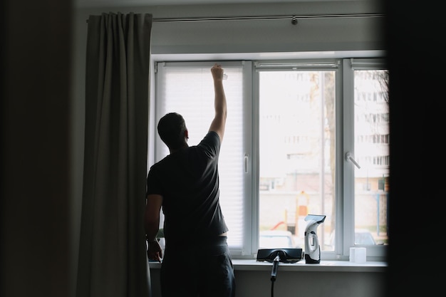 Homem lavando e limpando a janela em casa Trabalho doméstico e higiene doméstica