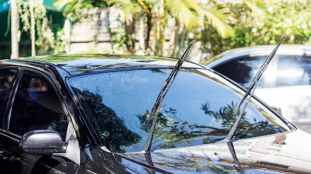 Homem lavando o carro preto.