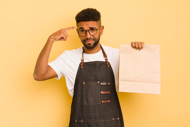 Homem legal afro se sentindo confuso e confuso, mostrando que você é um entregador insano e conceito de fast food