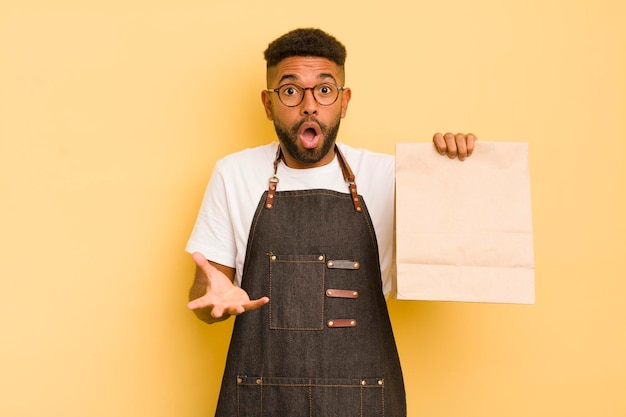 Homem legal afro surpreendeu chocado e surpreso com um entregador surpresa inacreditável e conceito de fast food