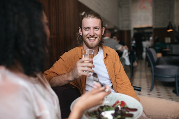 Homem legal sentado em um restaurante conversando com uma mulher