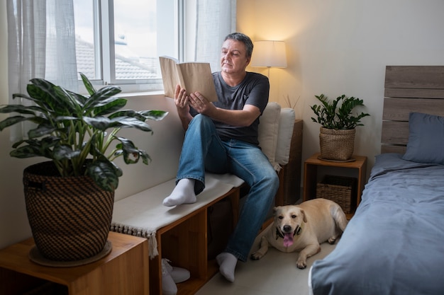 Homem lendo em casa com seu companheiro de cachorro