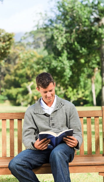 Foto homem lendo seu livro no banco