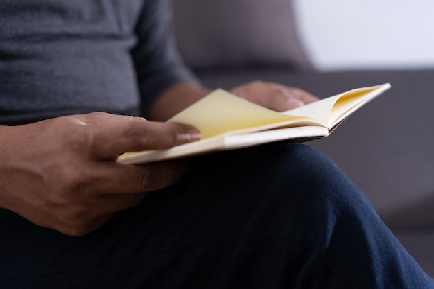 homem lendo um livro e segurando a xícara de café Sit Read Knowledge