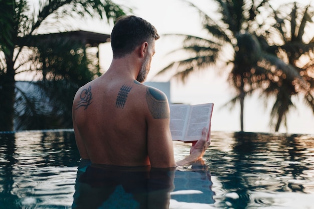 Homem, lendo um livro, em, a, piscina