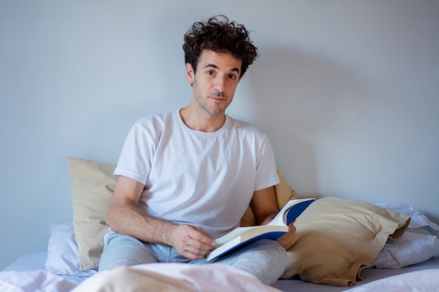 Homem lendo um livro na cama