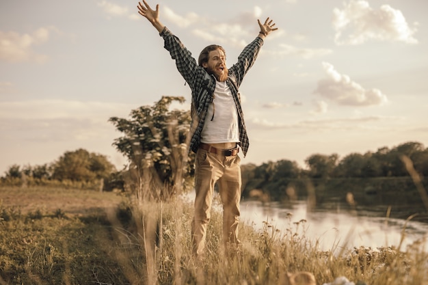 Foto homem levantando os braços e gritando na natureza selvagem