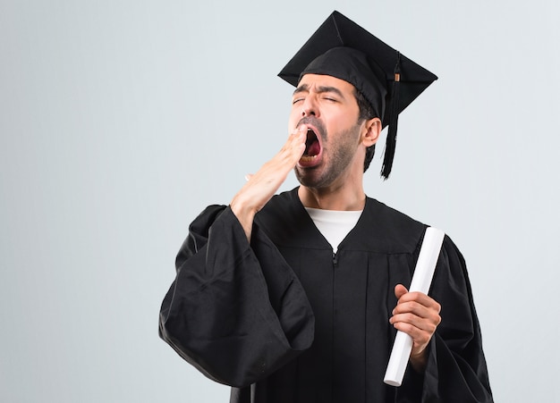 Homem, ligado, seu, dia formatura, universidade, bocejar, e, cobertura, boca aberta, com, mão