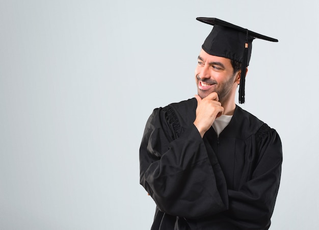 Homem, ligado, seu, dia graduação, universidade, ficar, e, olhar, ao lado, com, a, mão, ligado, a