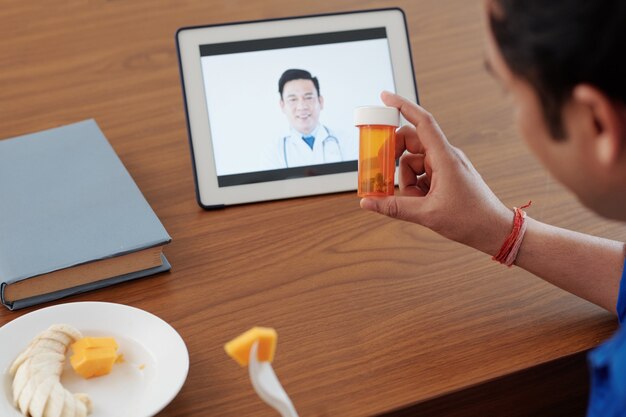 Homem ligando para o médico e perguntando se ele ainda deveria tomar vitaminas ou suplementos prescritos