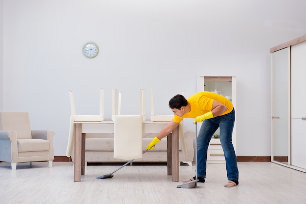 Homem limpando a casa ajudando sua esposa