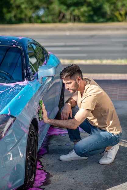 Foto homem limpando carro com guardanapo de espuma ao ar livre