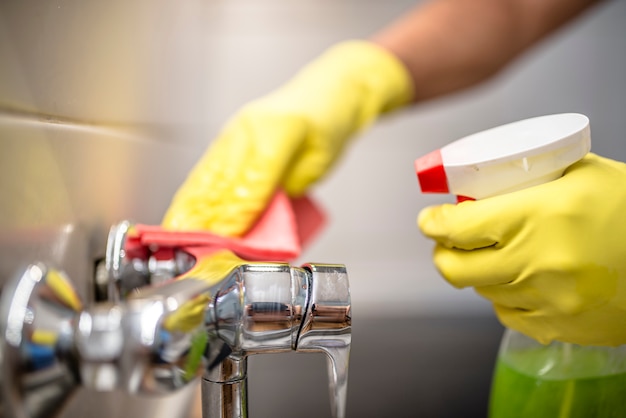 Homem limpando faucet na cozinha.